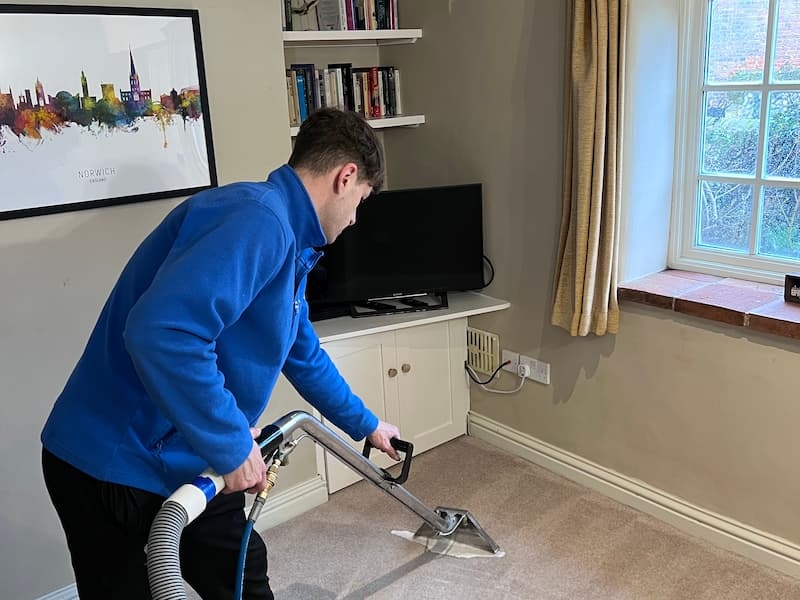A skilled carpet cleaning professional from The Norfolk Cleaning Group meticulously cleans a carpet with expertise, showcasing the company's specialty cleaning services.
