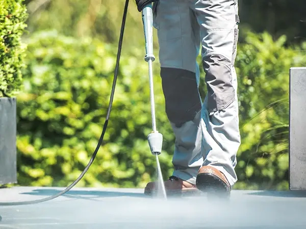 A professional cleaning team in action, revitalising driveways and patios using industrial power-wash equipment and safe, proven cleaning products, ensuring a thorough and effective cleaning process